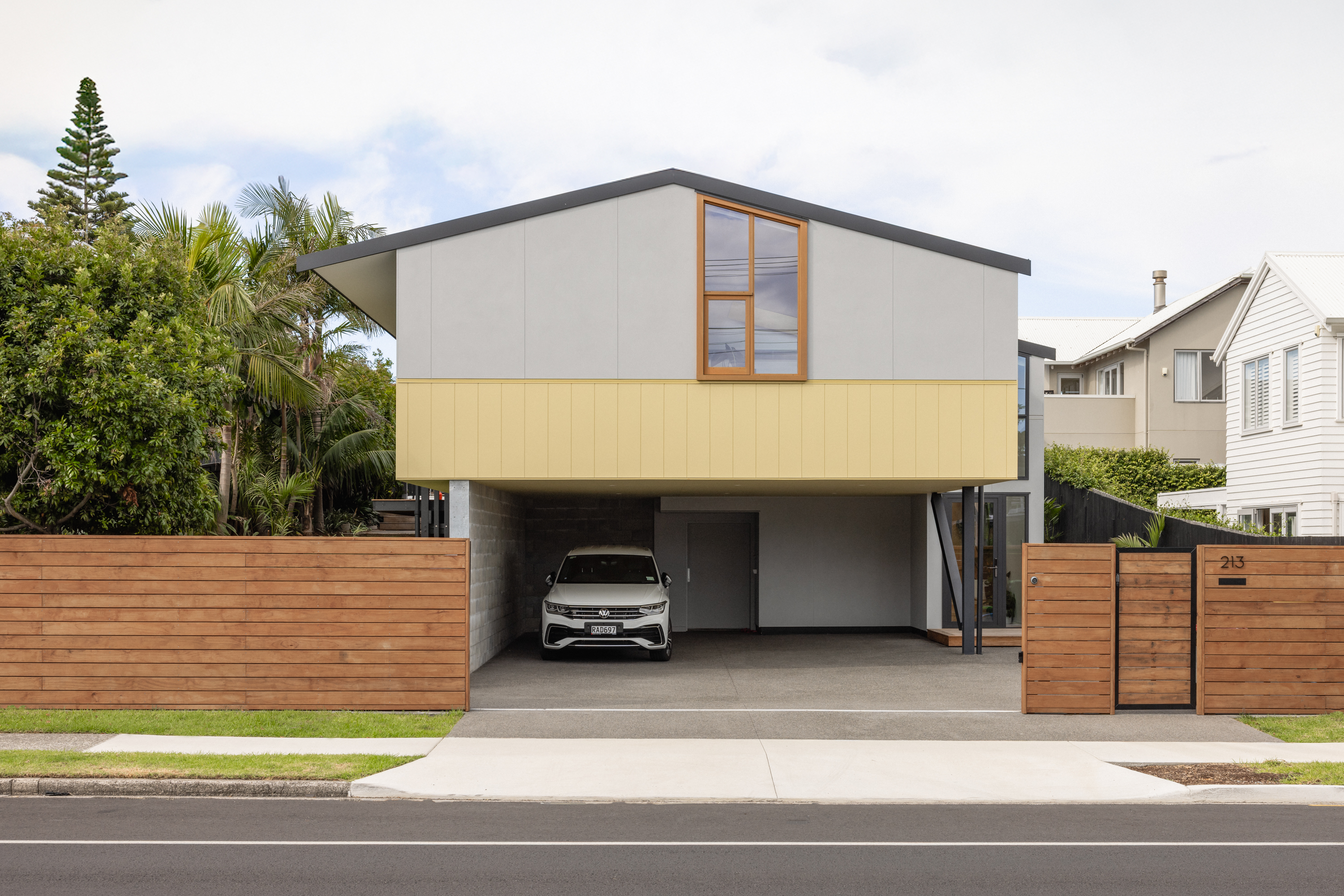 OB MAC — contemporary coastal home with mustard cladding and recessed undercroft