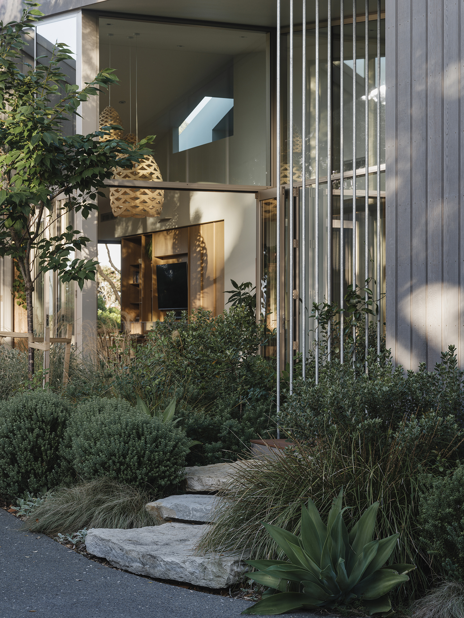 Treefold garden entry — stone step, planted understorey and vertical timber screens